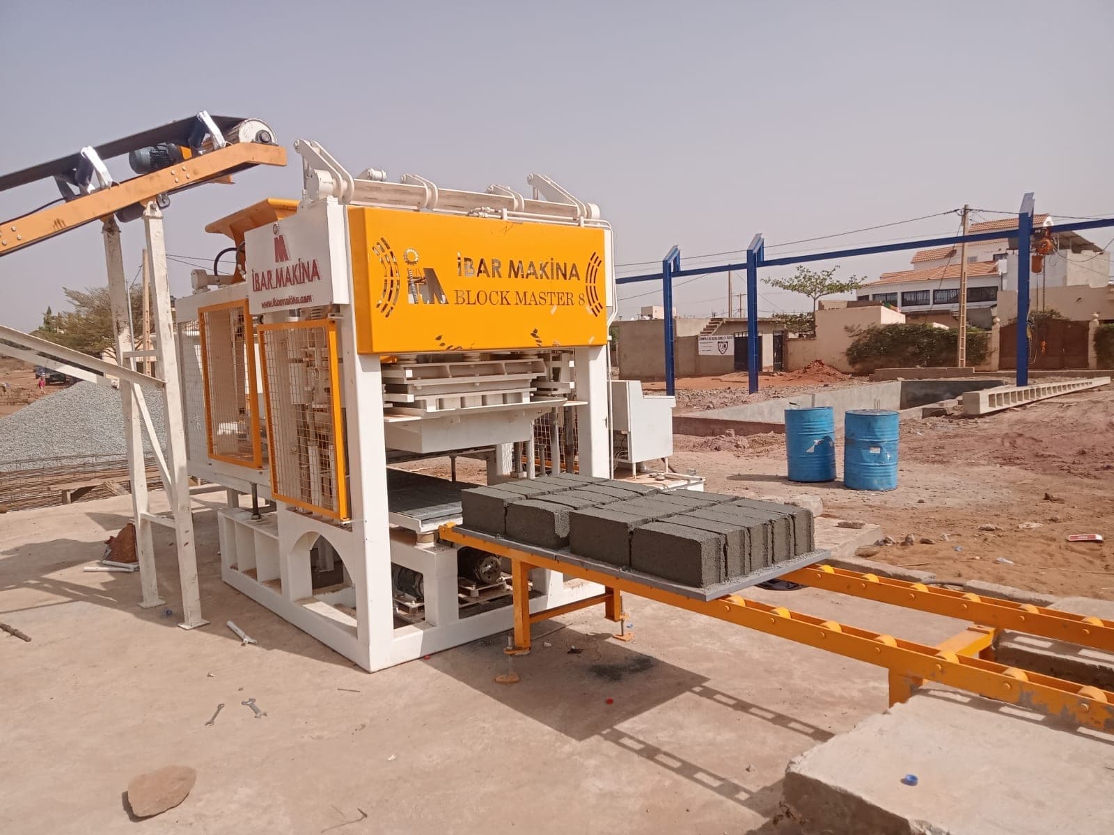 BLOCKMASTER 8 block machine with fresh hollow blocks on the pallet conveyor, Bamako