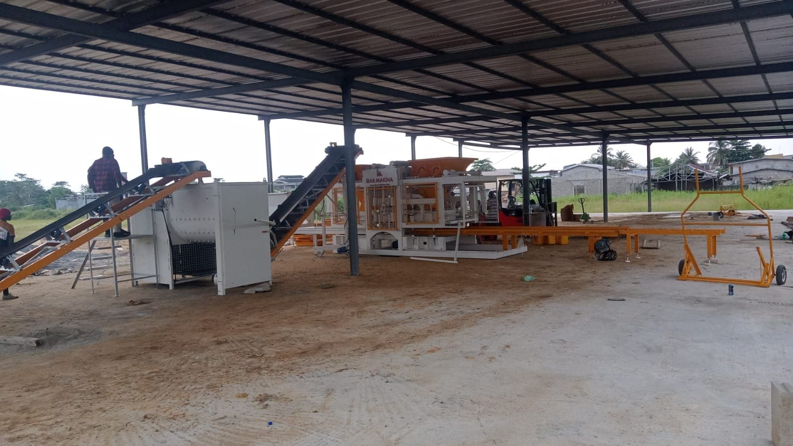 CBM 25 block plant in Gabon: mixer, inclined belt conveyors and block machine under a steel shed