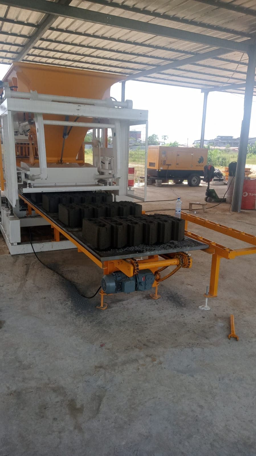 Fresh 20 cm hollow blocks leaving the CBM 25 block machine in Gabon