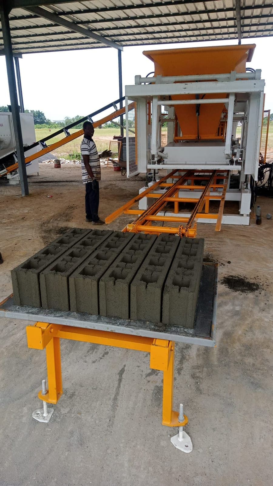 Pallet of hollow concrete blocks in front of the CBM 25 machine, Gabon